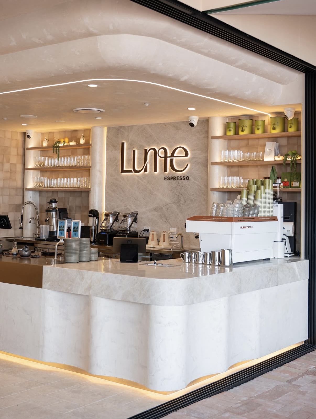 Café counter and curved ceiling with pale decorative finishes