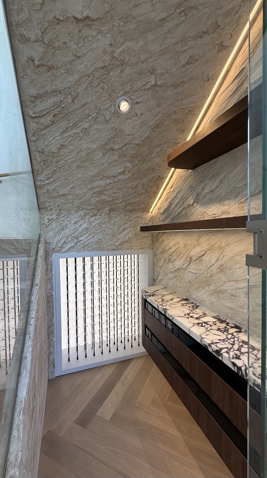 Full-height textured feature wall beside floating shelves