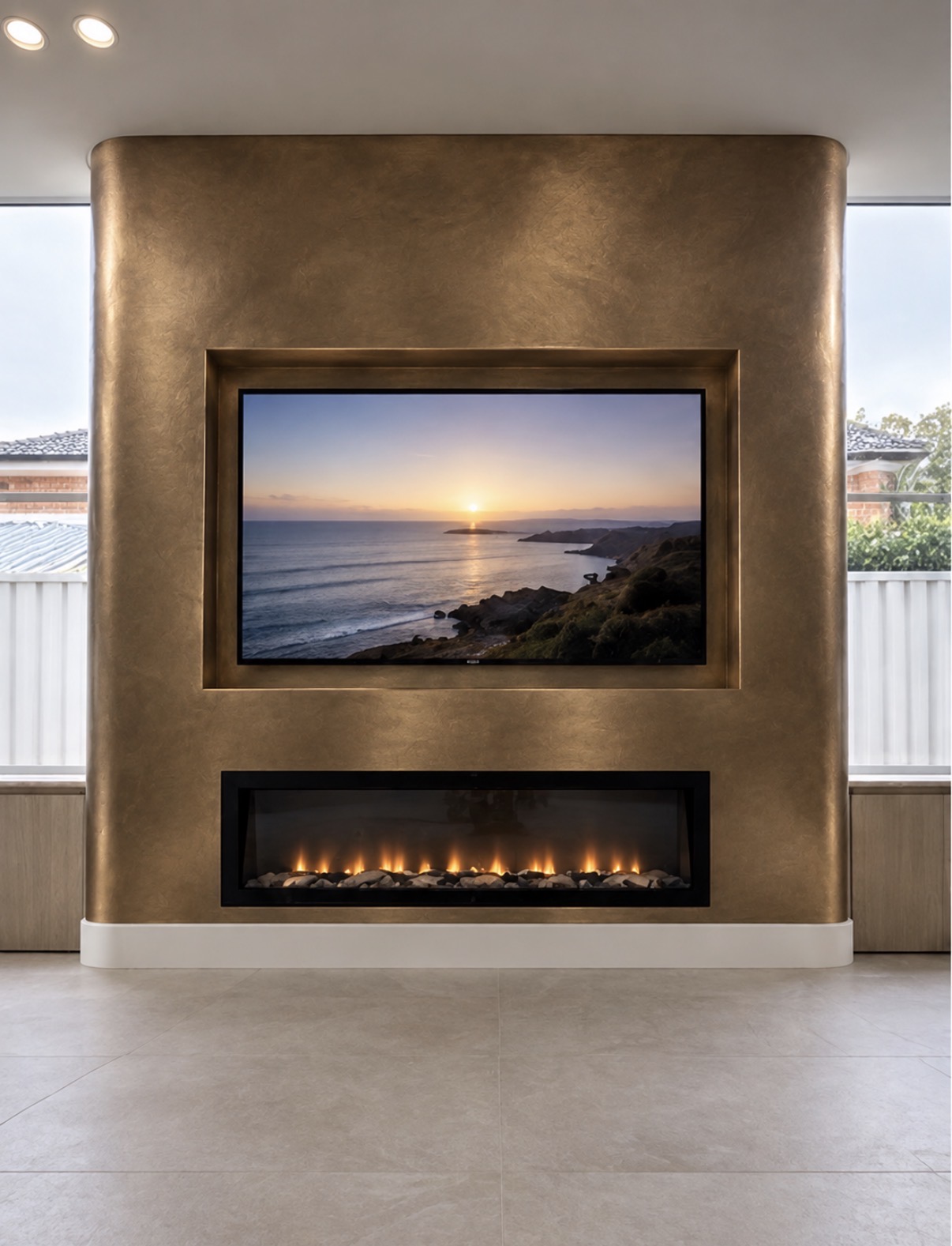 A bronze-toned media wall with integrated television and fireplace