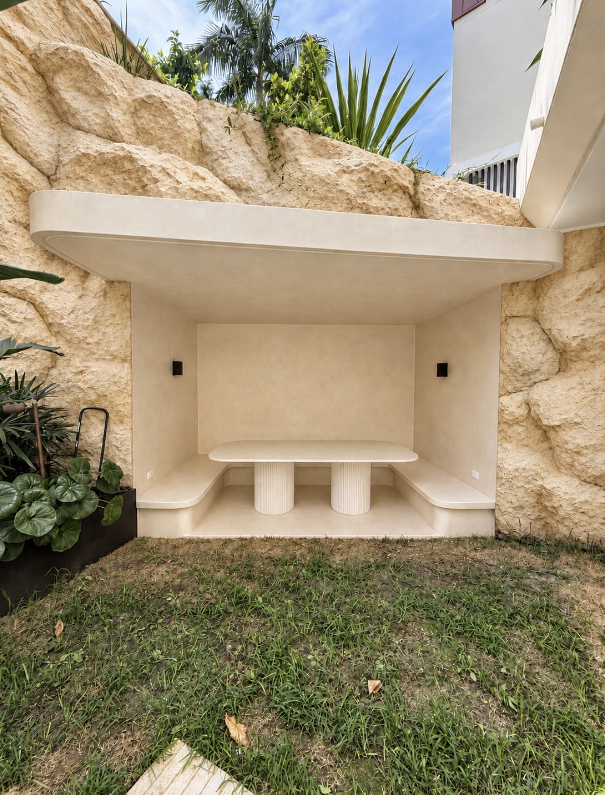 Pale curved outdoor seating surrounded by rock-textured walls